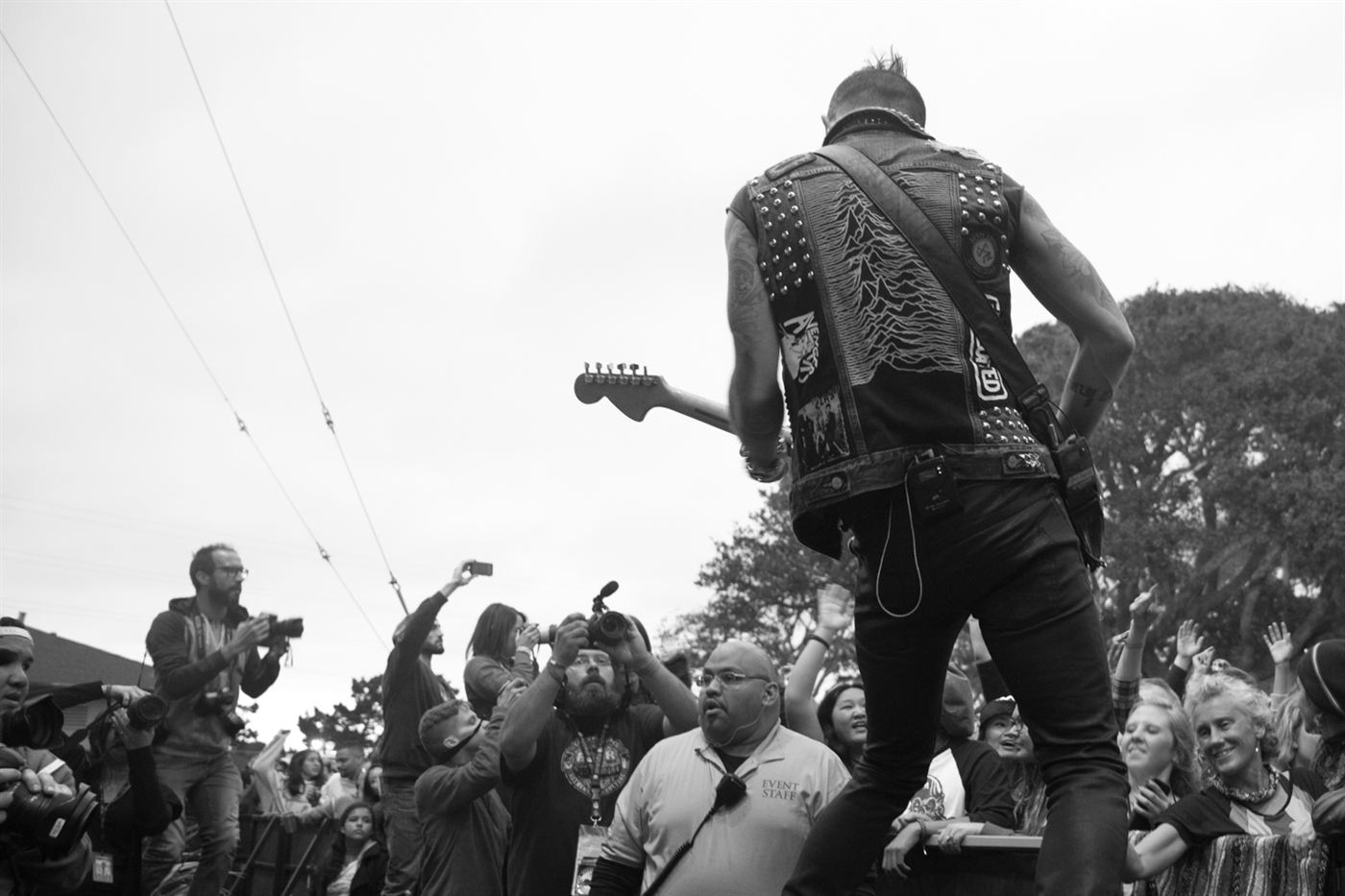 Guitarist performing near the edge of the stage during a live music festival.