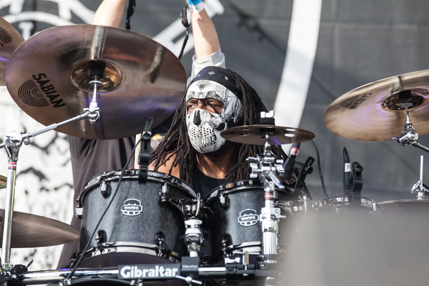 Drummer performing live on stage during a music festival.
